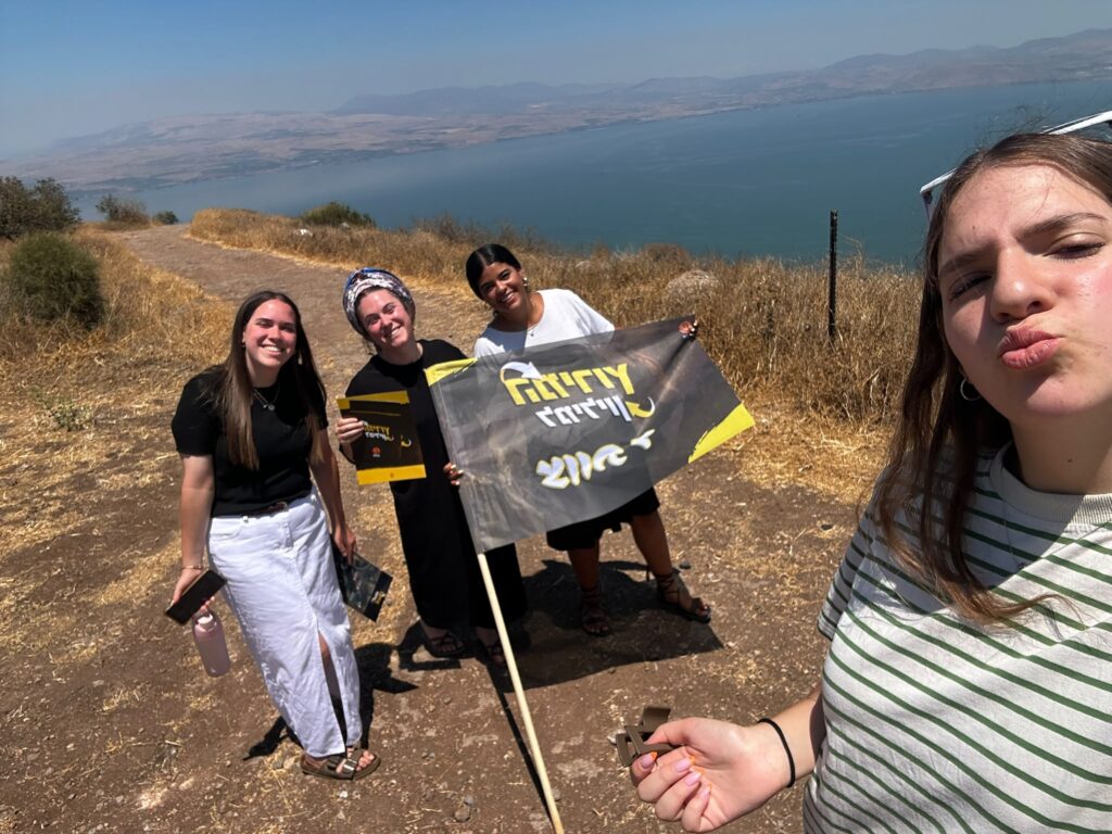 משתתפות מצטלמות עם שלט המירוץ למיליון במהלך משימת צילום